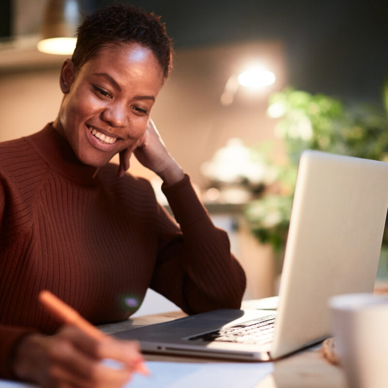 Woman working from home, handwriting a document.