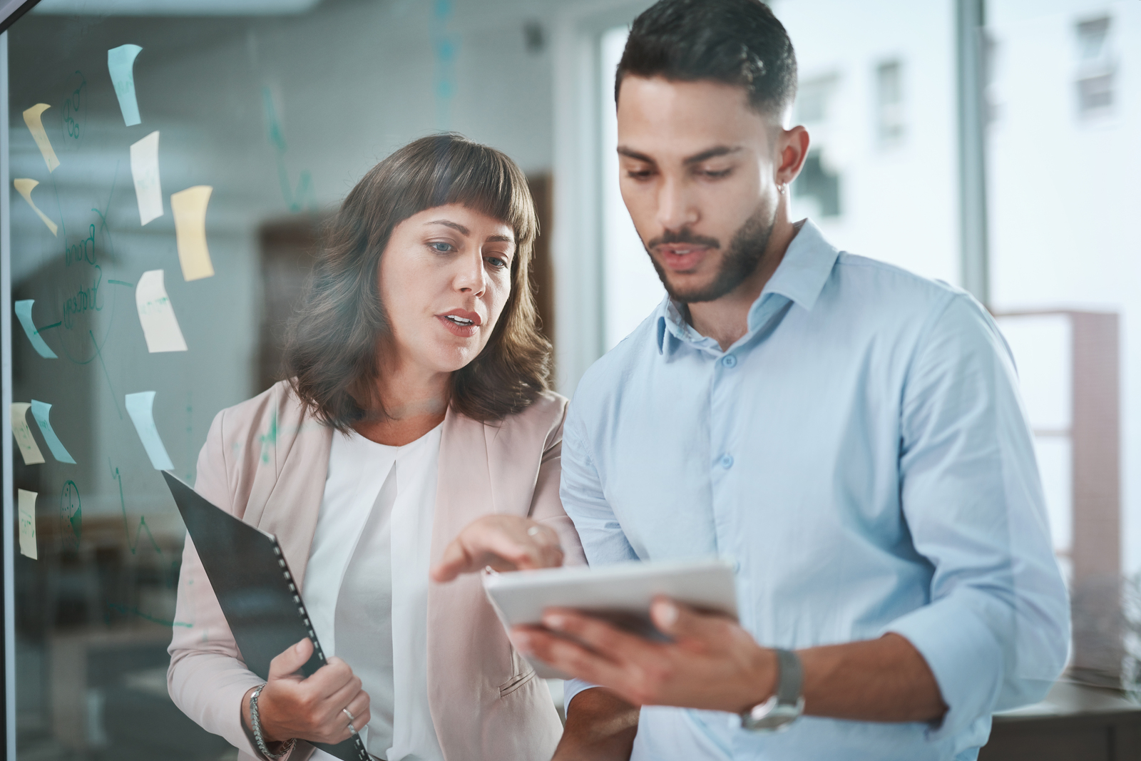 Shot of a young businessman and businesswoman using a digital tablet during a brainstorming session in a modern office